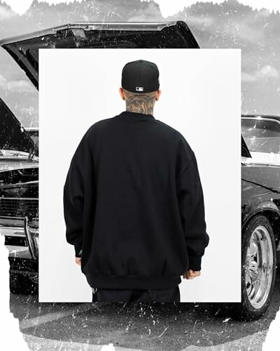Man in black sweatshirt and cap facing away with a car in the background