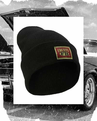 The black beanie hat with logo in front of a vintage car, showcasing the stylish and casual look of the hat.