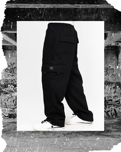 Person wearing black cargo pants with graffiti backdrop.