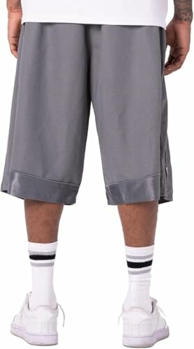 Back view of person wearing gray basketball shorts, white socks, and sneakers, showcasing the flexibility and comfort features of the Pro Club Men's Heavyweight Mesh Basketball Shorts.
