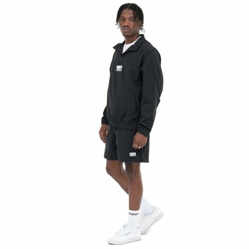 Man wearing black sports outfit with sneakers