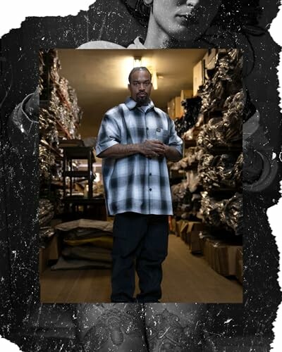 Man in checkered shirt standing in a warehouse.