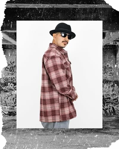 Man in plaid jacket and hat with a graffiti background.