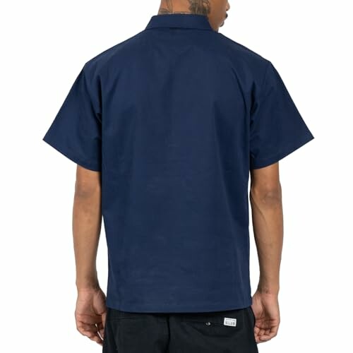 Person wearing a navy blue short-sleeve shirt, back view.