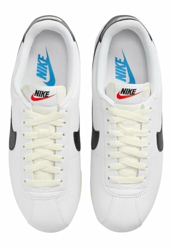 Top view of white Nike Cortez sneakers with black swoosh.