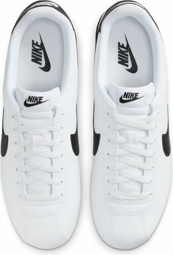 Top view of white Nike sneakers with black swoosh.